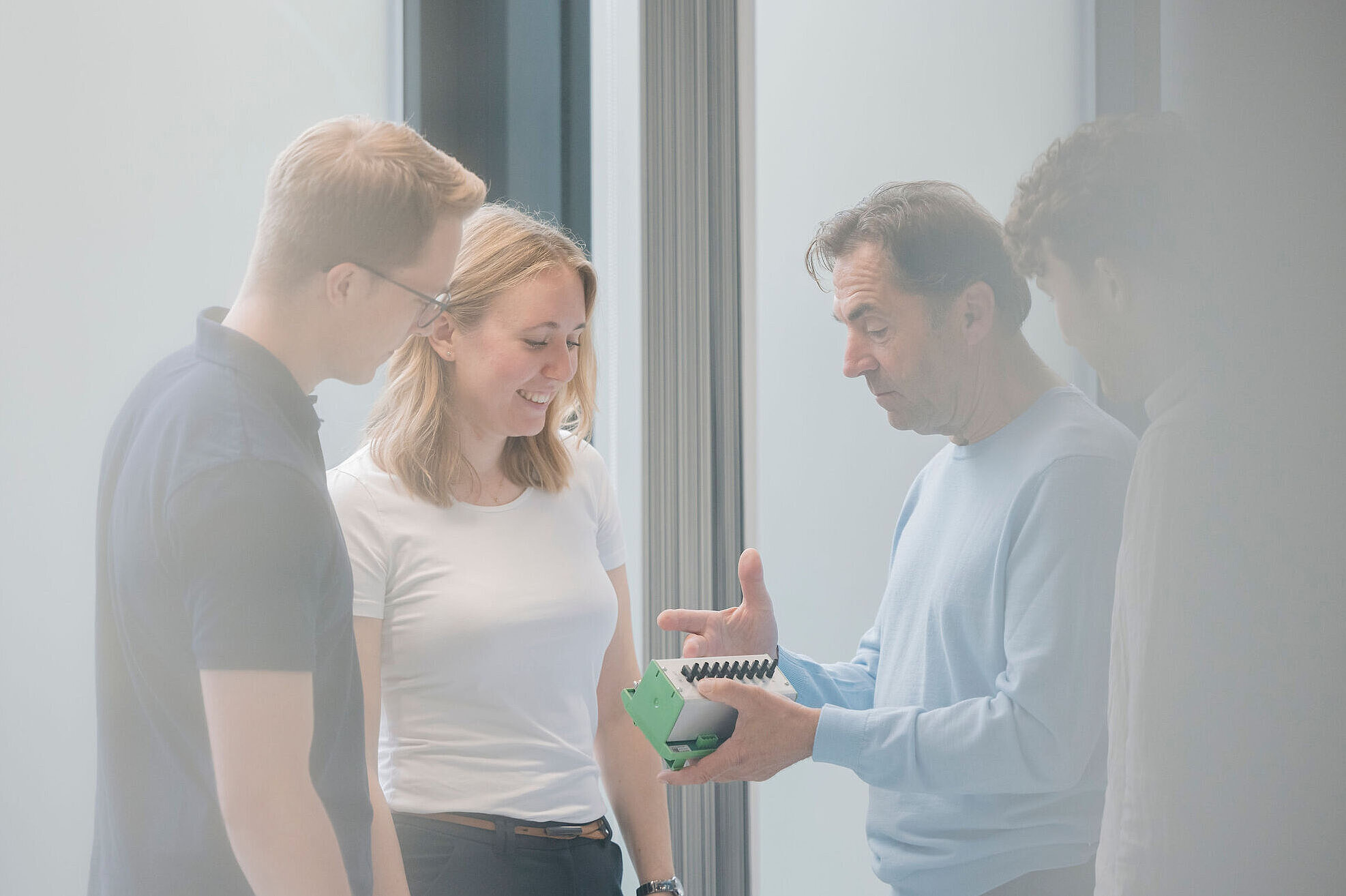 Ingenieure besprechen ein elektronisches Modul während der Entwicklung eines leistungselektronischen Systems.