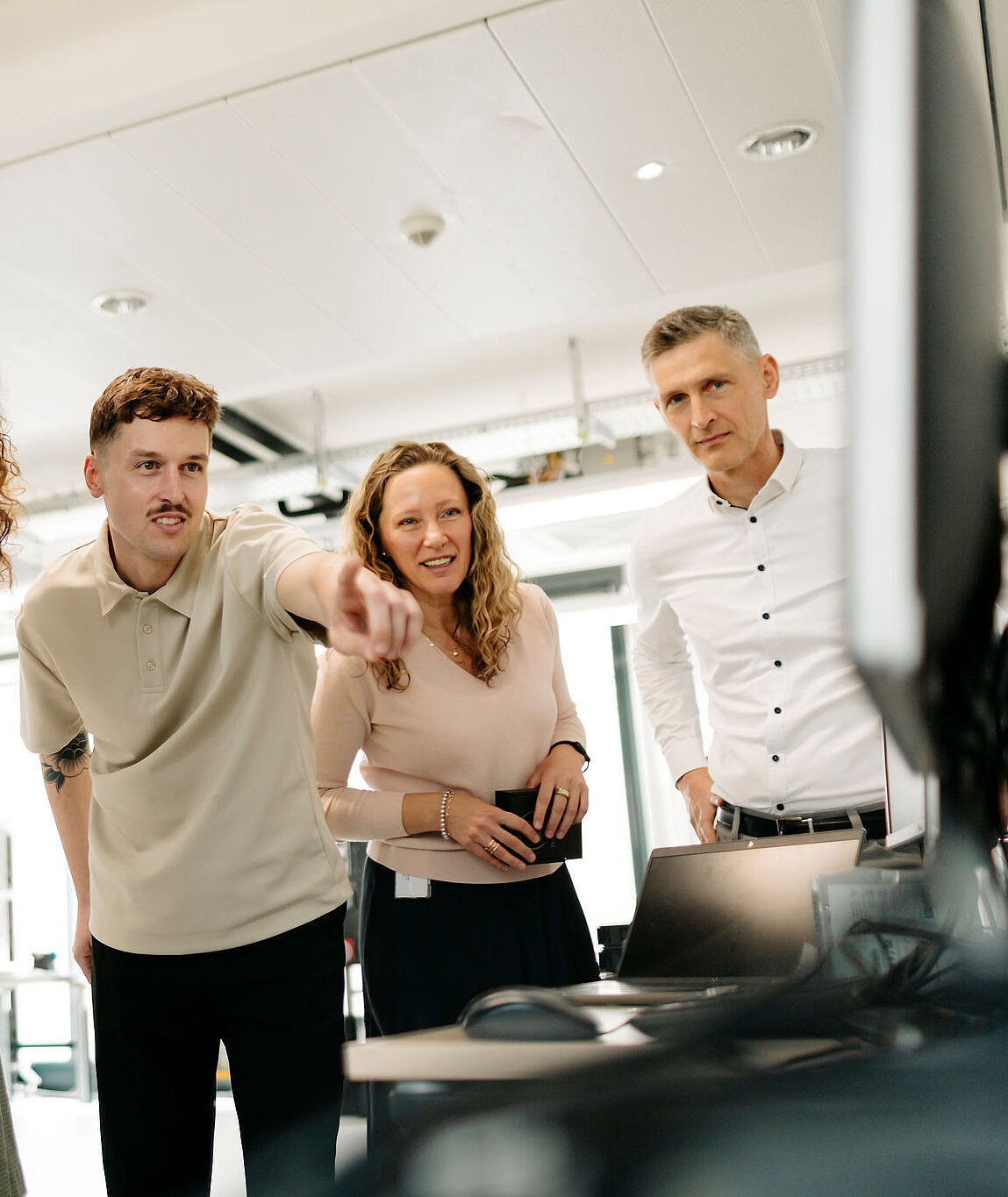 Fünf Mitarbeitende von Silver Atena besprechen technische Ergebnisse gemeinsam an einem Computerarbeitsplatz im Entwicklungslabor.