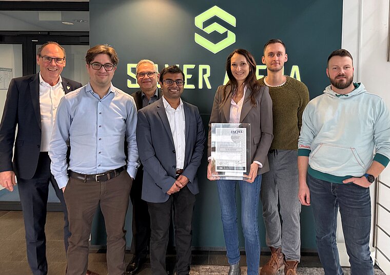Team vor Silver-Atena-Logo mit Vehicle Cyber Security Urkunde in der Hand