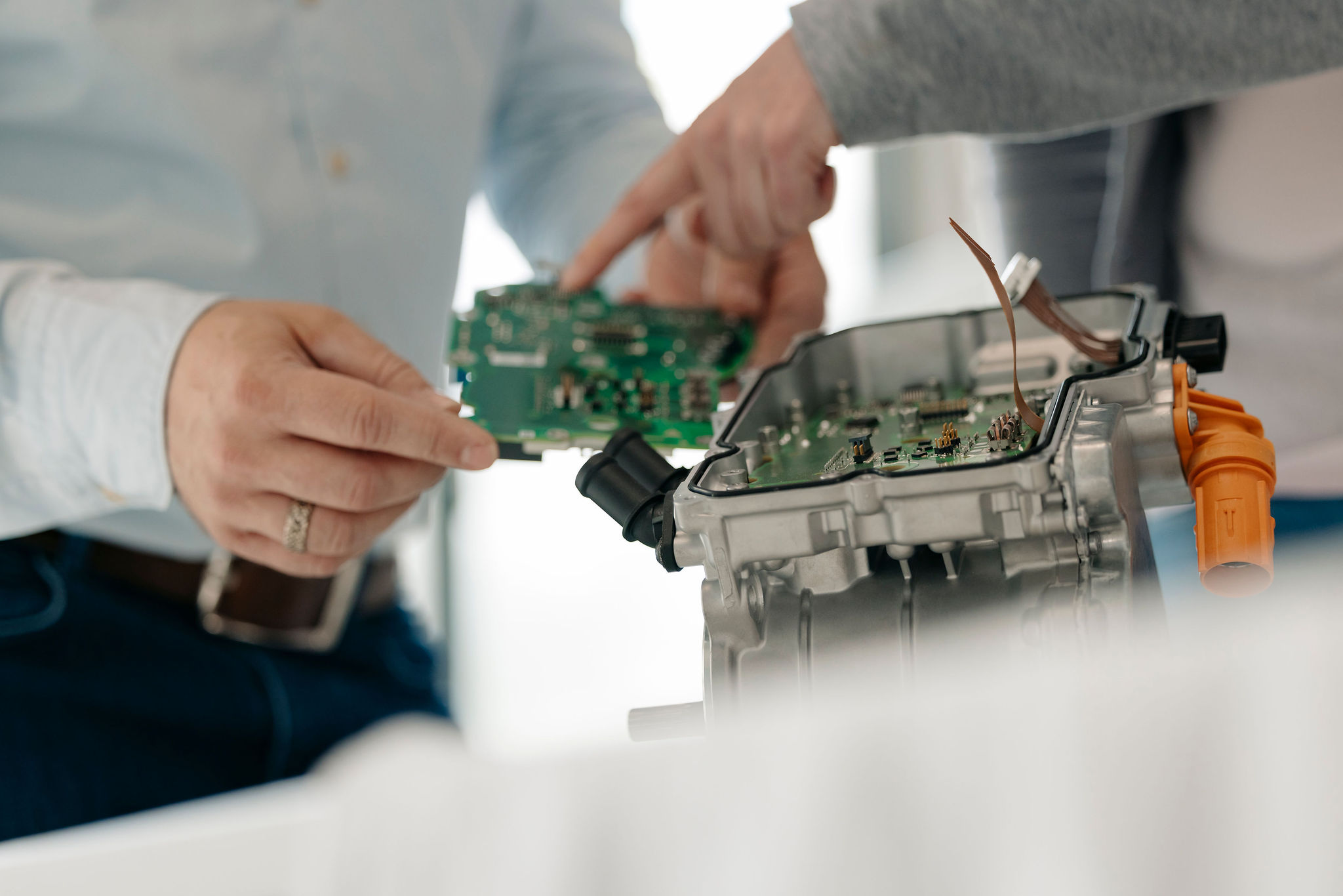 Zwei Ingenieure von Silver Atena untersuchen eine elektronische Leiterplatte und deren Integration in ein Steuergerätegehäuse.