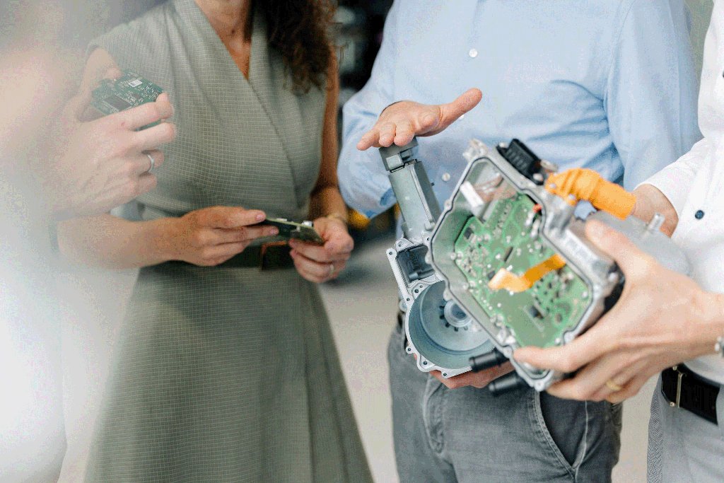 Mitarbeitende von Silver Atena besprechen elektronische Leiterplatten und geöffnete Gehäusebaugruppen während der Produktentwicklung.