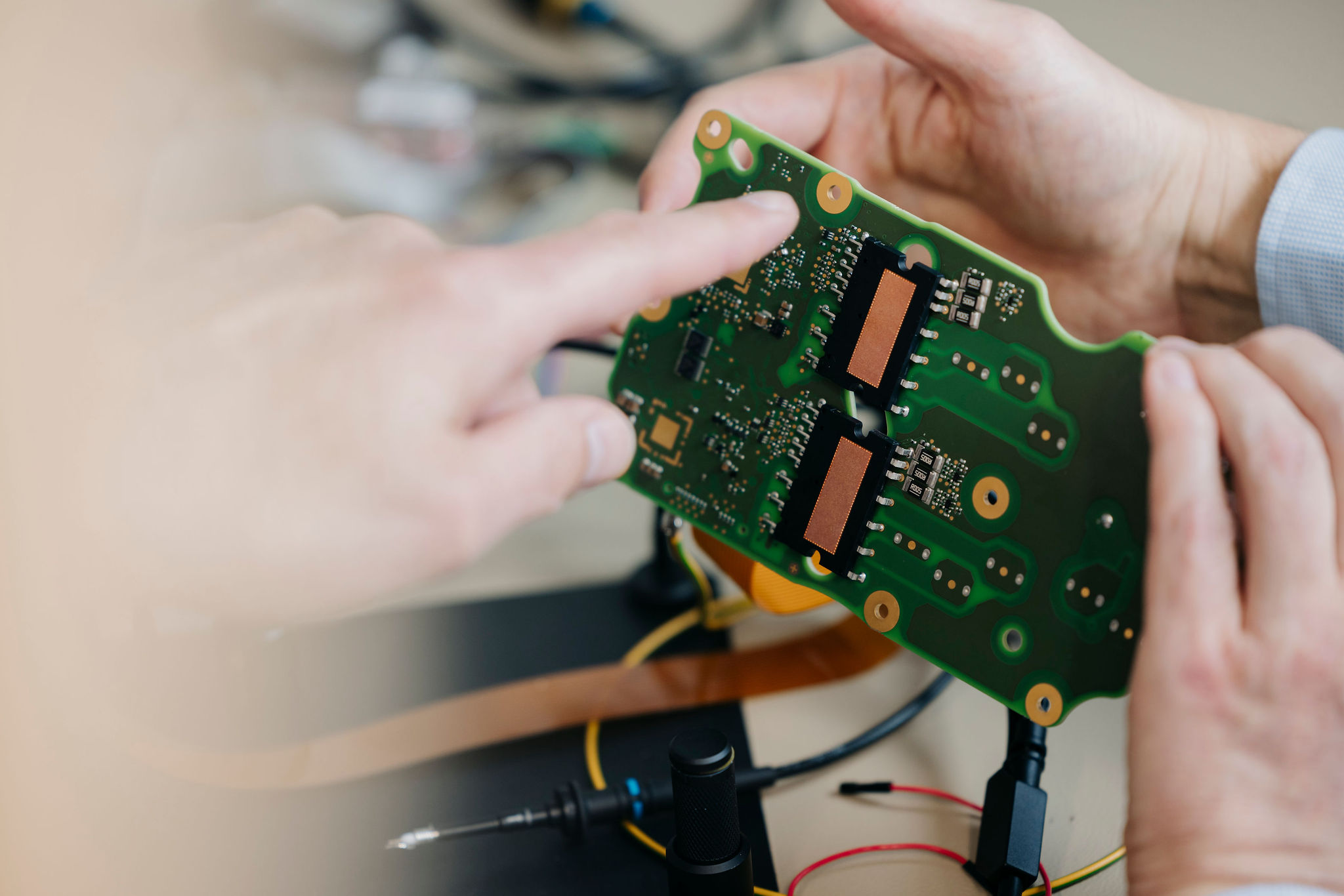 Detailaufnahme einer bestückten elektronischen Leiterplatte, auf deren Bauteile während einer technischen Analyse gezeigt wird.
