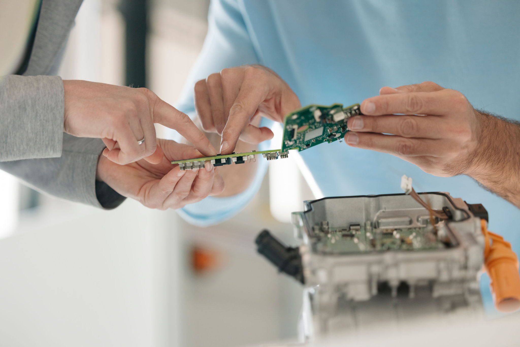 Zwei Mitarbeitende von Silver Atena besprechen elektronische Leiterplatten und deren Integration in ein geöffnetes Steuergerätegehäuse.