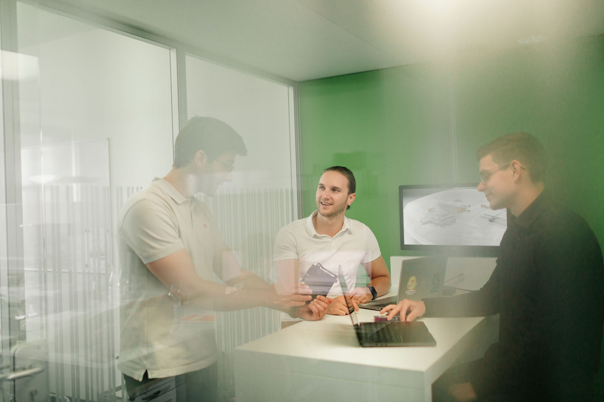 Ingenieure von Silver Atena besprechen ein technisches Bauteil während eines Entwicklungsmeetings.